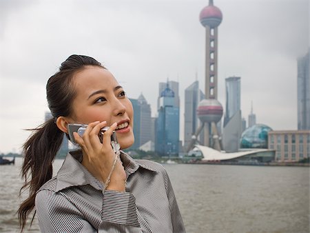 simsearch:640-01601405,k - Businesswoman outdoors on cell phone with city skyline in background Foto de stock - Royalty Free Premium, Número: 640-02775604