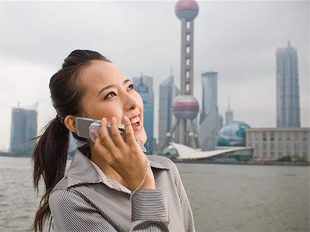 simsearch:640-01601405,k - Businesswoman outdoors on cell phone with city skyline in background Foto de stock - Royalty Free Premium, Número: 640-02775605