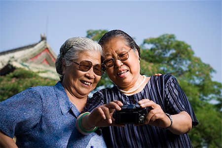 simsearch:640-01601334,k - Two women embracing outdoors with camera Stock Photo - Premium Royalty-Free, Code: 640-02775625