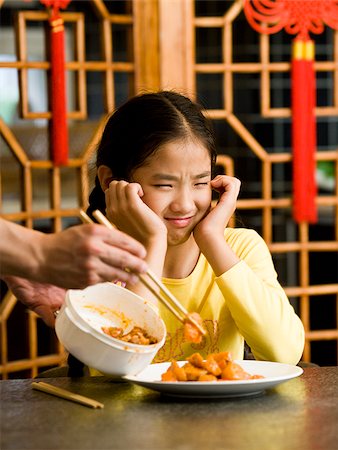 simsearch:640-02775249,k - Girl sitting at table looking at plate of food with disgust Stock Photo - Premium Royalty-Free, Code: 640-02775684