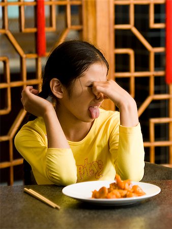 simsearch:640-02775249,k - Girl sitting at table looking at plate of food with disgust Stock Photo - Premium Royalty-Free, Code: 640-02775685