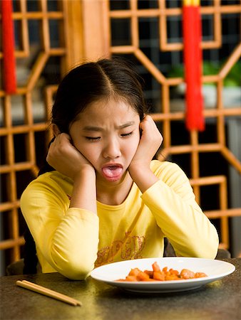 simsearch:640-02775249,k - Girl sitting at table looking at plate of food with disgust Stock Photo - Premium Royalty-Free, Code: 640-02775682