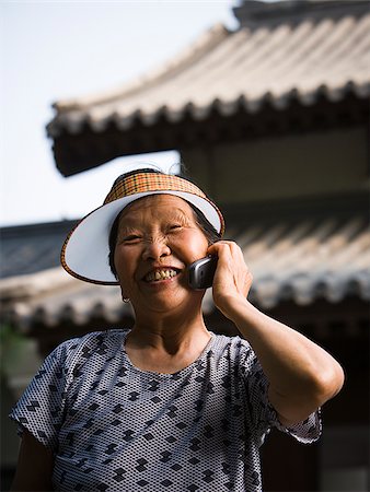 simsearch:640-01601405,k - Woman with sun visor outdoors smiling talking on cell phone Foto de stock - Royalty Free Premium, Número: 640-02775716