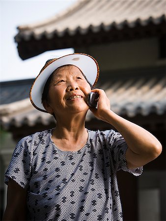 simsearch:640-01601405,k - Woman with sun visor outdoors smiling talking on cell phone Foto de stock - Royalty Free Premium, Número: 640-02775717