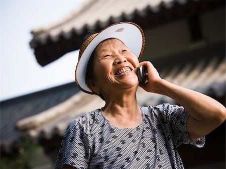 simsearch:640-01601405,k - Woman with sun visor outdoors smiling talking on cell phone Foto de stock - Royalty Free Premium, Número: 640-02775711