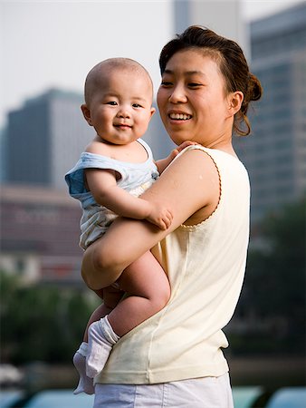 simsearch:640-01458949,k - Femme tenant un bébé souriant de plein air Photographie de stock - Premium Libres de Droits, Code: 640-02775727
