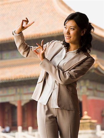 simsearch:640-01601473,k - Businesswoman doing tai chi outdoors smiling Foto de stock - Royalty Free Premium, Número: 640-02775780