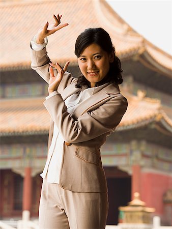 simsearch:640-01645712,k - Businesswoman doing tai chi outdoors smiling Stock Photo - Premium Royalty-Free, Code: 640-02775781