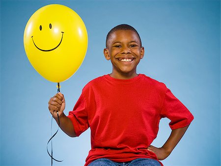 smiley face boy - Child holding a balloon. Stock Photo - Premium Royalty-Free, Code: 640-02776098