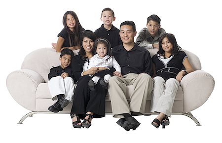 simsearch:640-02776733,k - Family sitting on a couch smiling. Foto de stock - Sin royalties Premium, Código: 640-02776722