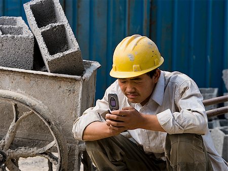 simsearch:640-02949618,k - Construction worker looking at his cell phone. Stock Photo - Premium Royalty-Free, Code: 640-02776850