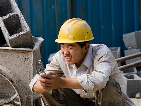 simsearch:640-02949616,k - Construction worker looking at his cell phone. Foto de stock - Royalty Free Premium, Número: 640-02776852