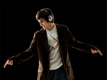 Young man listening to earphones and dancing. Stock Photo - Premium Royalty-Free, Code: 640-02776959