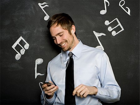 man listening to an mp3 player Foto de stock - Sin royalties Premium, Código: 640-02778171