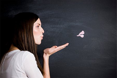 enviar besos - young woman against a chalkboard Foto de stock - Sin royalties Premium, Código: 640-02778327