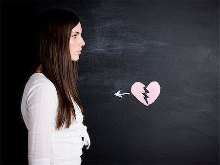 young woman against a chalkboard Stock Photo - Premium Royalty-Free, Code: 640-02778329