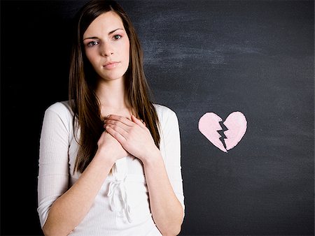 young woman against a chalkboard Stock Photo - Premium Royalty-Free, Code: 640-02778331