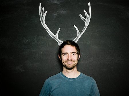 person with deer - man against a chalkboard Stock Photo - Premium Royalty-Free, Code: 640-02778366