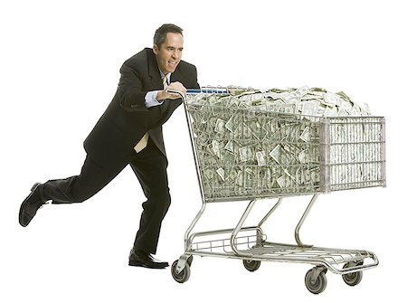 businessperson with a shopping cart full of money Stock Photo - Premium Royalty-Free, Code: 640-02778438