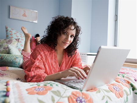 simsearch:640-02778481,k - femme allongée sur un lit avec un ordinateur portable Photographie de stock - Premium Libres de Droits, Code: 640-02778484