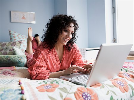 simsearch:640-02953250,k - woman lying on a bed with a notebook computer Stock Photo - Premium Royalty-Free, Code: 640-02778485