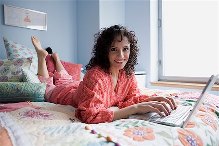 simsearch:640-02953250,k - woman lying on a bed with a notebook computer Stock Photo - Premium Royalty-Free, Code: 640-02778483