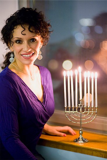 Woman lighting a menorah Stock Photo - Premium Royalty-Free, Image code: 640-02778504