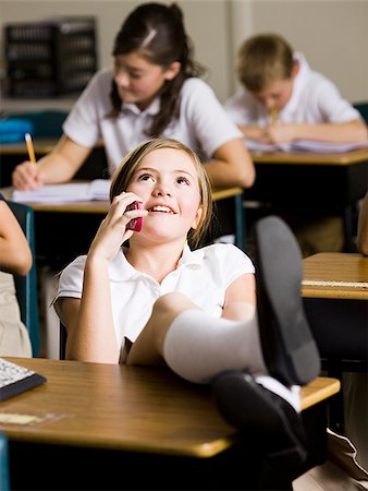 girl talking on phone in classroom Stock Photo - Premium Royalty-Free, Code: 640-02778956