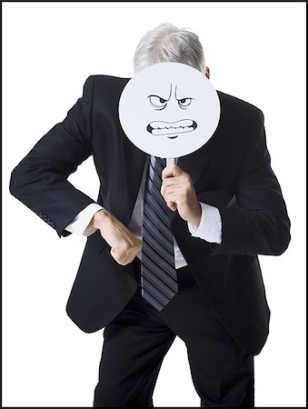 Businessman holding a determined face mask Stock Photo - Premium Royalty-Free, Code: 640-02770101