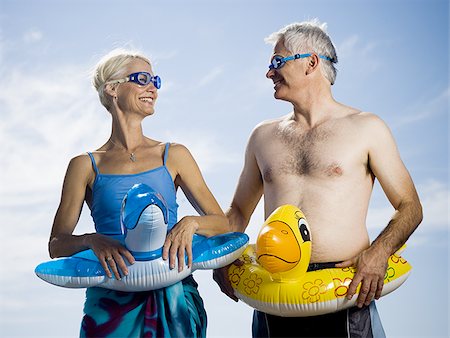 Couple with swimming rings around waist Stock Photo - Premium Royalty-Free, Code: 640-02770160