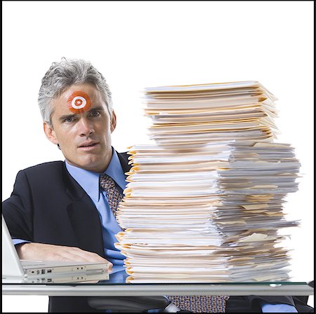 singled out - Man with bull's-eye on forehead working on laptop Stock Photo - Premium Royalty-Free, Code: 640-02770182