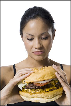 Woman eating a supersized hamburger Stock Photo - Premium Royalty-Free, Code: 640-02770320