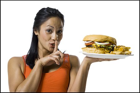 Woman eating a supersized hamburger Stock Photo - Premium Royalty-Free, Code: 640-02770342