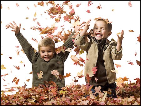 Young children playing in pile of fallen leaves Stock Photo - Premium Royalty-Free, Code: 640-02770478