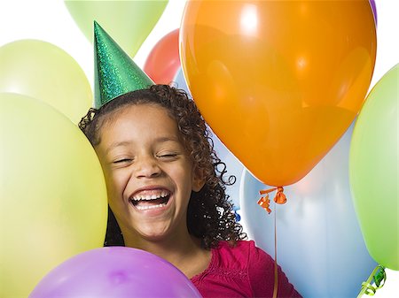 simsearch:640-02770515,k - Young girl wearing party hat and playing amongst balloons Foto de stock - Royalty Free Premium, Número: 640-02770504