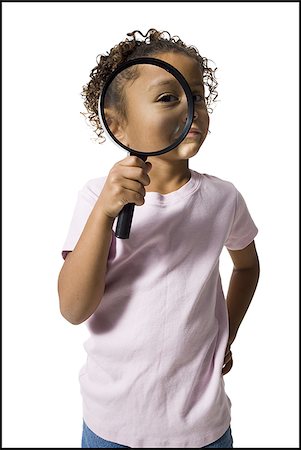 Young girl looking through magnifying glass Stock Photo - Premium Royalty-Free, Code: 640-02770505