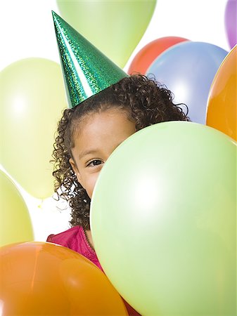 simsearch:640-02770515,k - Young girl wearing party hat and playing amongst balloons Foto de stock - Royalty Free Premium, Número: 640-02770503