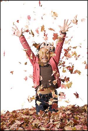 Young girl playing in fallen leaves Stock Photo - Premium Royalty-Free, Code: 640-02770514