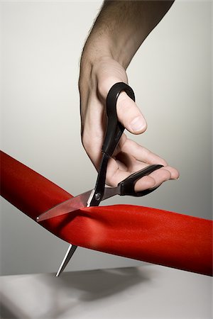 red ribbon - Hand cutting a red ribbon with scissors Stock Photo - Premium Royalty-Free, Code: 640-02770534