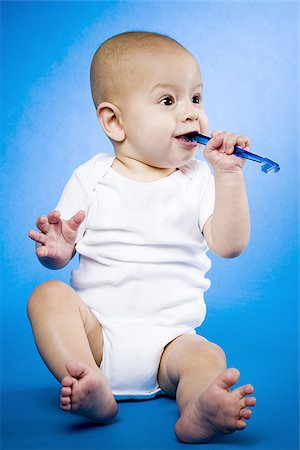 Baby chewing on toothbrush Stock Photo - Premium Royalty-Free, Code: 640-02770846