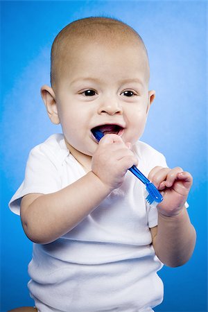 Baby chewing on toothbrush Stock Photo - Premium Royalty-Free, Code: 640-02770847
