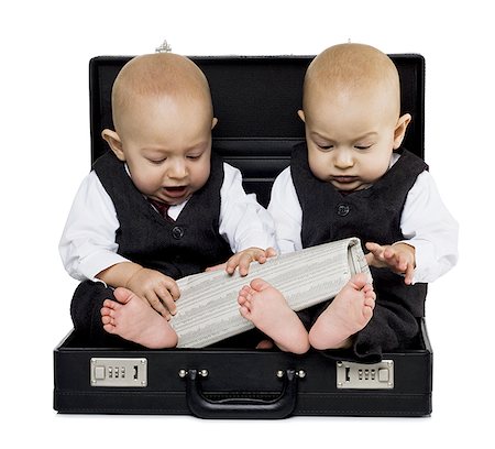 Twin baby boys in briefcase with suits and newspaper Stock Photo - Premium Royalty-Free, Code: 640-02770857