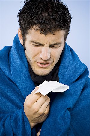 Man wrapped in blanket with tissue Stock Photo - Premium Royalty-Free, Code: 640-02770911
