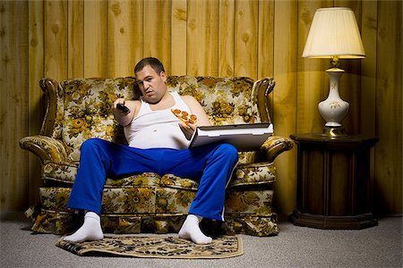 simsearch:640-02771087,k - Man on sofa with pizza and TV remote Foto de stock - Sin royalties Premium, Código: 640-02771076