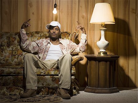 Man sitting on sofa under light bulb pointing up Foto de stock - Sin royalties Premium, Código: 640-02771126