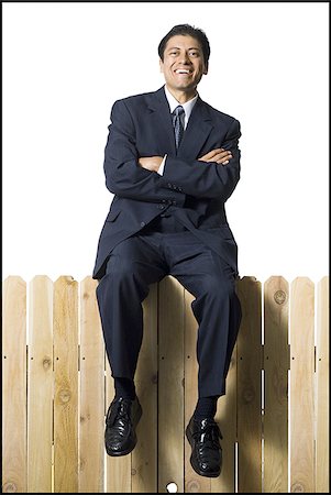 simsearch:640-02771261,k - Businessman sitting on fence smiling Stock Photo - Premium Royalty-Free, Code: 640-02771239