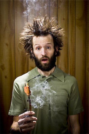 electrocuted man hair funny - Man with smoking hair and electrical plug Stock Photo - Premium Royalty-Free, Code: 640-02771282