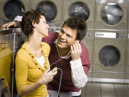 simsearch:640-02773489,k - Couple listening to mp3 player in Laundromat Fotografie stock - Premium Royalty-Free, Codice: 640-02771637