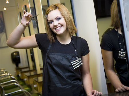 simsearch:640-01458486,k - Young woman standing and smiling in beauty salon with scissors Foto de stock - Sin royalties Premium, Código: 640-02771716