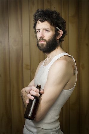 Homme debout avec les bras croisés et de bouteille de bière Photographie de stock - Premium Libres de Droits, Code: 640-02771713